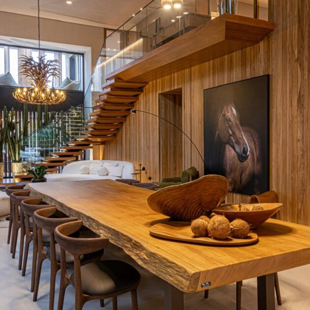 Escada flutuante de madeira ao lado da sala de jantar