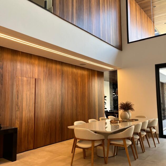 Parede revestida com painel de madeira na sala de jantar