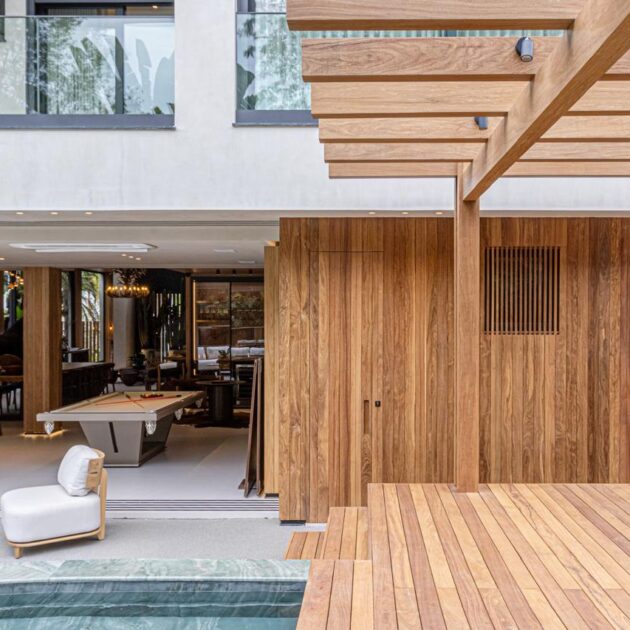 Área de lazer com deck, painel e pergolado de madeira